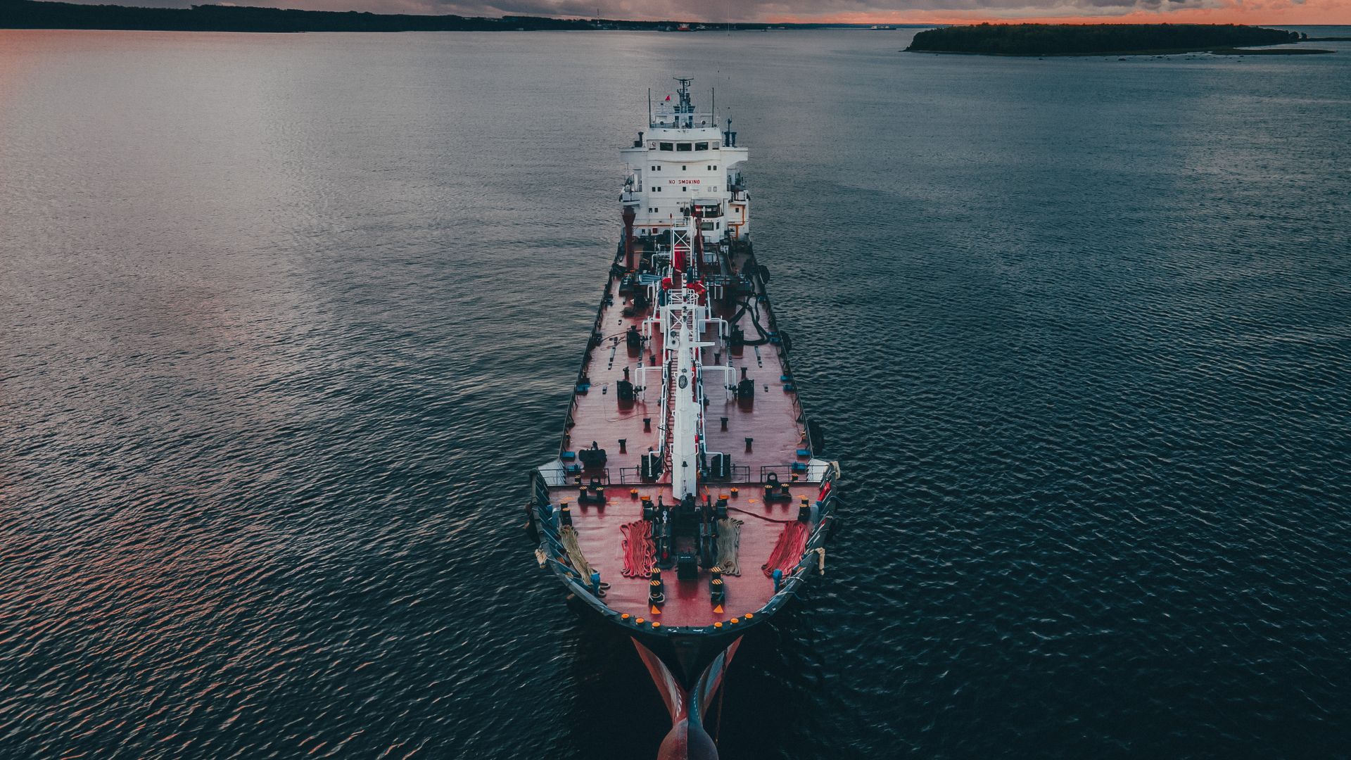 Commercial vessel navigating open waters at twilight